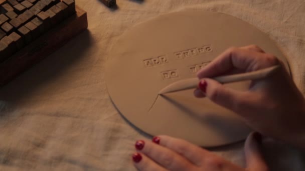 Stampa di lettere su lastre di argilla in officina. Stoviglie decorative in ceramica fatta a mano primo piano. — Video Stock