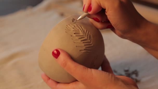 Göra en lervas i verkstaden närbild. Flickornas händer applicerar textur och allvar på leran. — Stockvideo