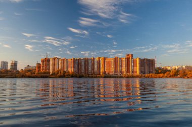 Maviye karşı gölün yüzeyine yansıyan binalar 