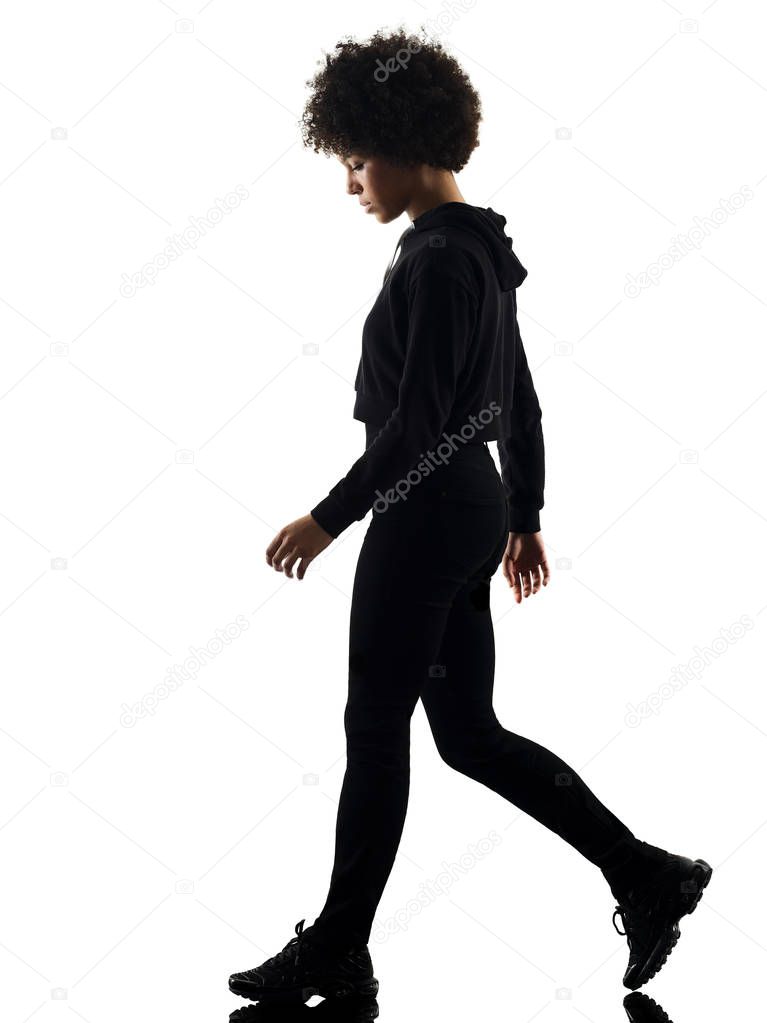 one mixed race african young teenager girl woman walking sadness in studio shadow silhouette isolated on white background