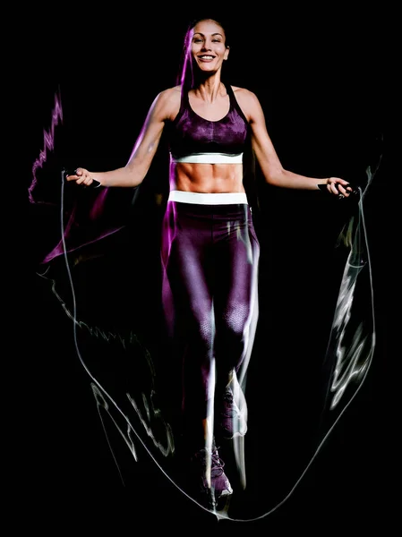 Beautiful woman jumping rope fitness exercises isolated black background — Stock Photo, Image