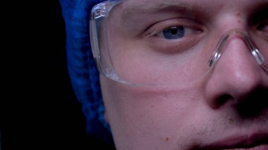 Cerrah ya da giyen doktor gözlük, tıbbi kapağı, koyu arka plan, makro mavi gözleri.