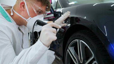 Parlatma ve arabalar, boyama sonra profesyonel master denetler el feneri çizikler, solunum, beyaz lastik eldiven, beyaz önlük, Gözlük, oto servisi.