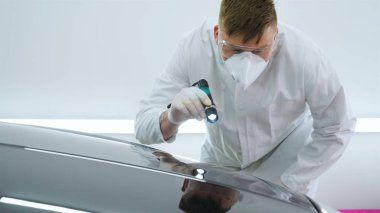 Parlatma ve arabalar, boyama sonra profesyonel master denetler el feneri çizikler, solunum, beyaz lastik eldiven, beyaz önlük, Gözlük, oto servisi.