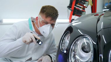 Parlatma ve arabalar, boyama sonra profesyonel master denetler el feneri çizikler, solunum, beyaz lastik eldiven, beyaz önlük, Gözlük, oto servisi.