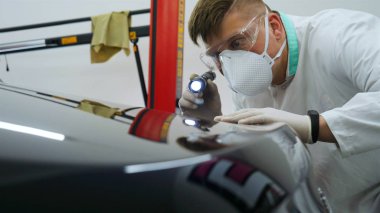 Parlatma ve arabalar, boyama sonra profesyonel master denetler el feneri çizikler, solunum, beyaz lastik eldiven, beyaz önlük, Gözlük, oto servisi.