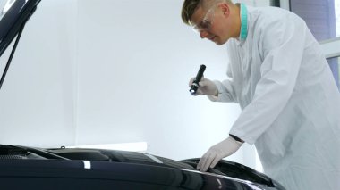 Parlatma ve arabalar, boyama sonra profesyonel master denetler el feneri çizikler, solunum, beyaz lastik eldiven, beyaz önlük, Gözlük, oto servisi.