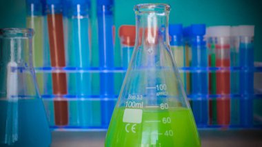 Şişe, testi farklı kompozisyonlar, yeşil arka plana sahip test tüpleri.