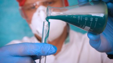 Simyaci bir biyolog, solunum, Gözlük, beyaz bir tıbbi elbisesi, bir şişesi, yeşil bir arka plan, bir bilim tablo içinde bir koruyucu kapak içinde çeşitli maddeler, Dna alır.