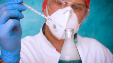 Simyaci bir biyolog, solunum, Gözlük, beyaz bir tıbbi elbisesi, bir şişesi, yeşil bir arka plan, bir bilim tablo içinde bir koruyucu kapak içinde çeşitli maddeler, Dna alır.