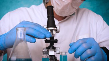 Simyaci bir biyolog, solunum, Gözlük, beyaz bir tıbbi elbisesi, bir şişesi, yeşil bir arka plan, bir bilim tablo içinde bir koruyucu kapak içinde çeşitli maddeler, Dna alır.