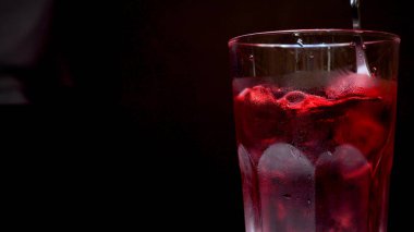 Buz, taze, soğuk, alkol, siyah arka plan ile kokteyl kırmızı bir kaşıkla bir barmen kıpırdanırken.