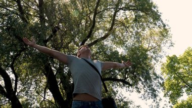 Genç yakışıklı adam, adam ücretsiz, Doğa, yeşil ağaçlar arka plan hisseder. Konsept: özgürlük, doğa.