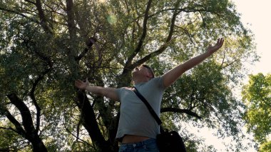 Genç yakışıklı adam, adam ücretsiz, Doğa, yeşil ağaçlar arka plan hisseder. Konsept: özgürlük, doğa.