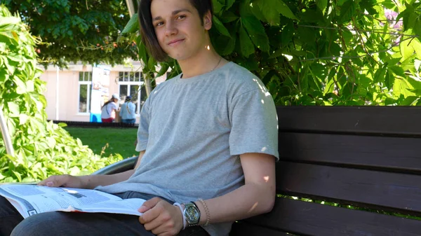 Cara Bonito Jovem Adolescente Está Sentado Banco Parque Lendo Livro — Fotografia de Stock