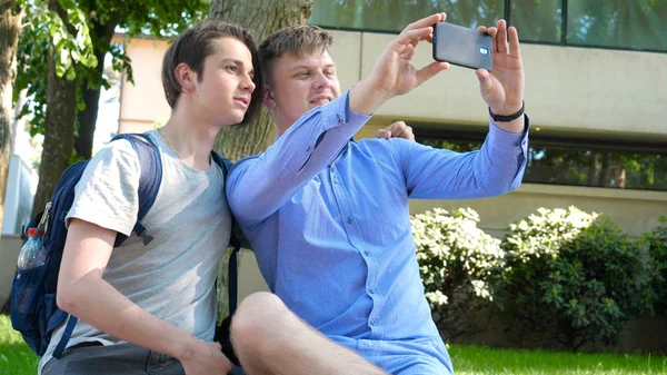Två Vänner Till Student Leende Tittar Telefonen Foton Parken Koncept — Stockfoto