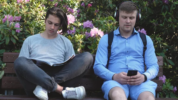 Dos Jóvenes Hermosos Adolescentes Leyendo Libro Escuchando Música Teléfono Móvil —  Fotos de Stock