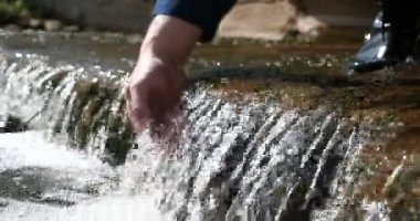 Bir adam elini tutar (ellerini yıkıyor) çeşmede (su), kir onları temizleyerek, ve elinin uzunluğu şelale su tutarak. Konser: su hissedin, yavaş hareket.
