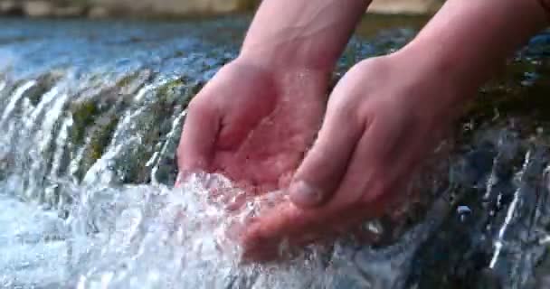 一个人把手 放在喷泉 清除泥土 用他的手把瀑布的水拿着 音乐会 感受水 慢动作 — 图库视频影像