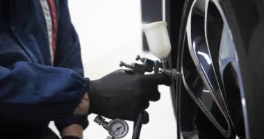 Ağır çekimde, elinde sprey tabanca ve koruyucu gözlüklü bir solunum cihazıyla çalışan bir erkek (erkek), elinde klasörlü bir el feneri ile bir araba motorunu kontrol eder. Otomatik merkez kavramı.