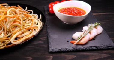 Evde pişirilen yemek (restoranda) aşçı bitmiş makarna tabağını rendelenmiş parmesan peyniri ile mutfak rendesinde süslüyor ve sos ekliyor. Peynir, muhteşem yemek, ağır çekim kavramı.