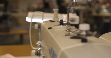Malzeme her iki tarafını kullanarak kırmızı kumaş üzerinde profesyonel bir makine, nakış (sews) ile terzi dikiş elleri. Konsept: fabrika, ev, Iş başında, profesyoneller.
