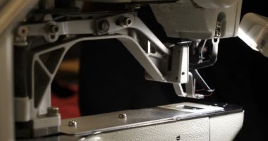 Malzeme her iki tarafını kullanarak kırmızı kumaş üzerinde profesyonel bir makine, nakış (sews) ile terzi dikiş elleri. Konsept: fabrika, ev, Iş başında, profesyoneller.