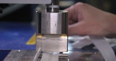 Bir giysi fabrikasında yavaş hareket video, kadın basın (Cut) Giyim ve kumaş kilitleri ve çeşitli malzemeler farklı makineler kullanarak çeşitli parçalar. Kavramı: Iş, fabrika, terzi.