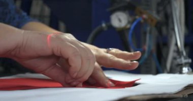 Bir giysi fabrikasında yavaş hareket video, kadın basın (Cut) Giyim ve kumaş kilitleri ve çeşitli malzemeler farklı makineler kullanarak çeşitli parçalar. Kavramı: Iş, fabrika, terzi.