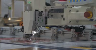 Otomatik tek başlı tek başlı iğne bilgisayar nakış makinesi / bilgisayar dikiş makineleri kumaşa çeşitli şeritler dikiyor. Otomatik dikiş makinesi, iş, giysi, tekstil kavramı.