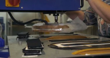 Bir giysi fabrikasında yavaş hareket video, kadın basın (Cut) Giyim ve kumaş kilitleri ve çeşitli malzemeler farklı makineler kullanarak çeşitli parçalar. Kavramı: Iş, fabrika, terzi.