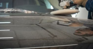 Ağır çekimde, elinde sprey tabanca ve koruyucu gözlüklü bir solunum cihazıyla çalışan bir erkek (erkek), elinde klasörlü bir el feneri ile bir araba motorunu kontrol eder. Otomatik merkez kavramı.