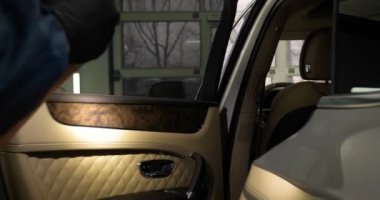 Ağır çekimde, elinde sprey tabanca ve koruyucu gözlüklü bir solunum cihazıyla çalışan bir erkek (erkek), elinde klasörlü bir el feneri ile bir araba motorunu kontrol eder. Otomatik merkez kavramı.