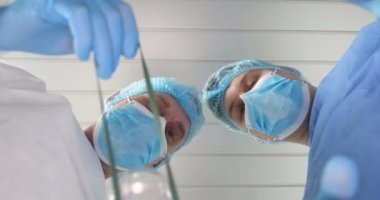 Hastanede, doktor ve doktor asistanı farklı tıbbi araçlar kullanarak tedavi işlemi gerçekleştirmek. Her iki doktor da başlıklarında ve eldivenleriyle cüppeli doktorlar. Kavramı: Diş hekimleri.