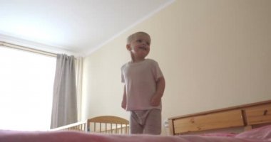 Küçük bir çocuk (çocuk) çok neşeli tam büyüme kanepede atlama olduğunu. Kavramı: Neşeli bebek, Sağlıklı çocuk, Gülümseme, Kahkaha, Yaşam Joy.