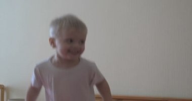 Küçük bir çocuk (çocuk) çok neşeli tam büyüme kanepede atlama olduğunu. Kavramı: Neşeli bebek, Sağlıklı çocuk, Gülümseme, Kahkaha, Yaşam Joy.