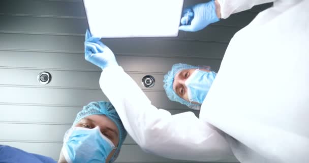 병원에서 의사와 의사의 조수는 도구를 사용하여 작업을 수행합니다 머리장식과 장갑을 — 비디오