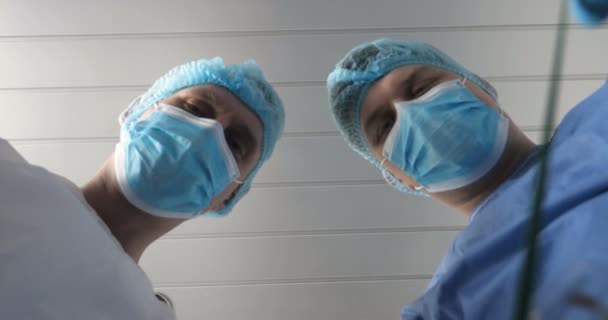 병원에서 의사와 의사의 조수는 도구를 사용하여 작업을 수행합니다 머리장식과 장갑을 — 비디오