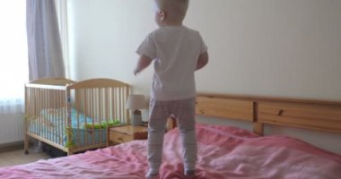 Küçük bir çocuk (çocuk) çok neşeli tam büyüme kanepede atlama olduğunu. Kavramı: Neşeli bebek, Sağlıklı çocuk, Gülümseme, Kahkaha, Yaşam Joy.