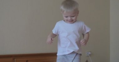 Küçük bir çocuk (çocuk) çok neşeli tam büyüme kanepede atlama olduğunu. Kavramı: Neşeli bebek, Sağlıklı çocuk, Gülümseme, Kahkaha, Yaşam Joy.