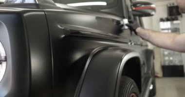 Araba boyama ve seramik iki profesyonel ustalar bir araba deteyling merkezinde, bir mikro fiber ve bez kullanarak seramik bir tabaka bindirme. Konsept: Servis, Yeni araba, Yenile.