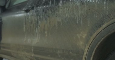 Garajda bir adam (araba servisi) araba alarmı kontrol eder ve sonra (geliyor) kapalı (açık) onun arkasındaki ışıkları açmak kapatır. Konsept: Oto Garaj, güvenlik.