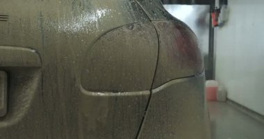 Garajda bir adam (araba servisi) araba alarmı kontrol eder ve sonra (geliyor) kapalı (açık) onun arkasındaki ışıkları açmak kapatır. Konsept: Oto Garaj, güvenlik.