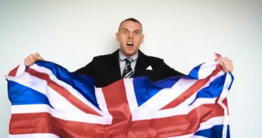 Yavaş çekimde bir adam (adam) Büyük Britanya Birleşik Krallığı (İngiliz) bir hayranı dır duygular elinde bir bayrak tutan ne olup bittiğini memnun. Kavramı: Brexit Out, Zafer, Kızgın.
