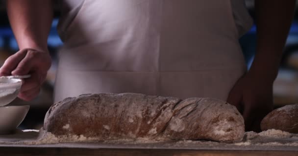 Der Bäckerei Streut Ein Bäcker Nach Dem Backen Von Frischem — Stockvideo