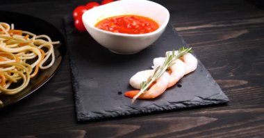 Evde pişirilen yemek (restoranda) aşçı bitmiş makarna tabağını rendelenmiş parmesan peyniri ile mutfak rendesinde süslüyor ve sos ekliyor. Peynir, muhteşem yemek, ağır çekim kavramı.