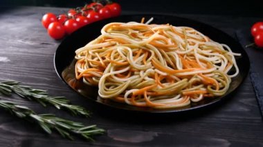 Evde pişirilen yemek (restoranda) aşçı bitmiş makarna tabağını rendelenmiş parmesan peyniri ile mutfak rendesinde süslüyor ve sos ekliyor. Peynir, muhteşem yemek, ağır çekim kavramı.