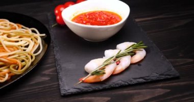 Evde pişirilen yemek (restoranda) aşçı bitmiş makarna tabağını rendelenmiş parmesan peyniri ile mutfak rendesinde süslüyor ve sos ekliyor. Peynir, muhteşem yemek, ağır çekim kavramı.