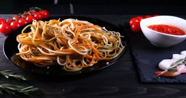 Evde pişirilen yemek (restoranda) aşçı bitmiş makarna tabağını rendelenmiş parmesan peyniri ile mutfak rendesinde süslüyor ve sos ekliyor. Peynir, muhteşem yemek, ağır çekim kavramı.