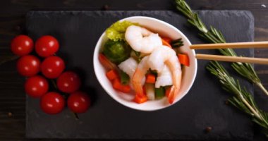 Beyaz eldiven bir şef bir deniz yemeği (salata) hazırlanan, karides parmesan peyniri sürtünme ve Çin çubukları kullanarak üstüne limon suyu sıkma ile süsler, sonra tatma. Kiraz domates arka plan.